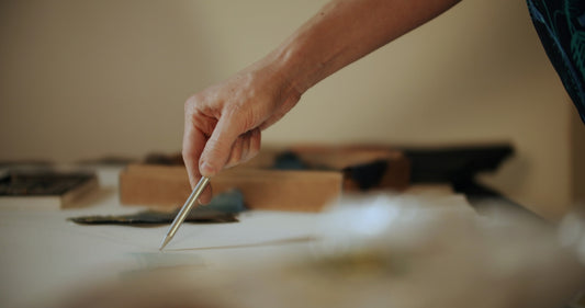 person holding silver pen on white paper