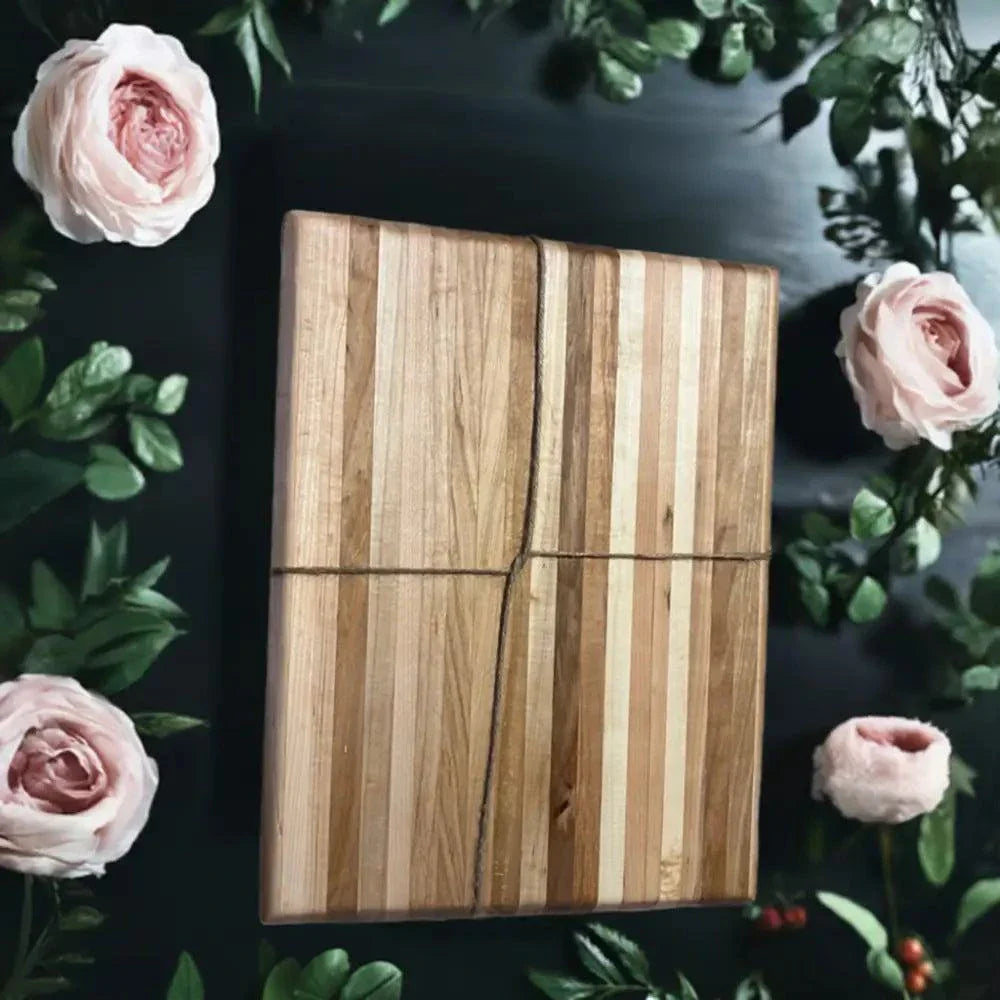 Handmade Hard Maple Cutting Board 10x13x1.5 Inches with Natural Grain Patterns and Smooth Finish Surrounded by Pink Flowers.