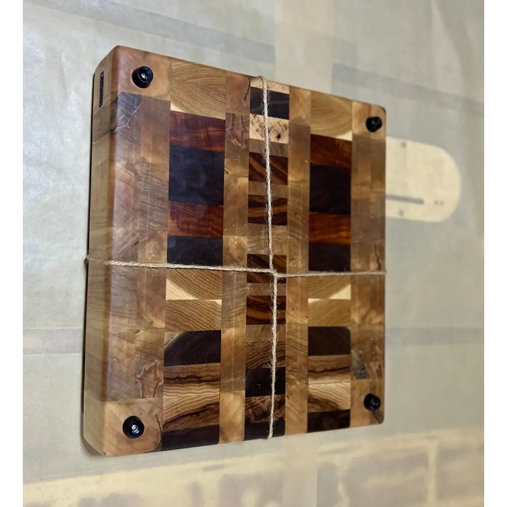 10.5"x11.5"x2.5" premium butcher block with non-slip feet, crafted from Ambrosia Maple, Hickory, Black Walnut, Tigerwood, and Canarywood, showcased on a flat surface.