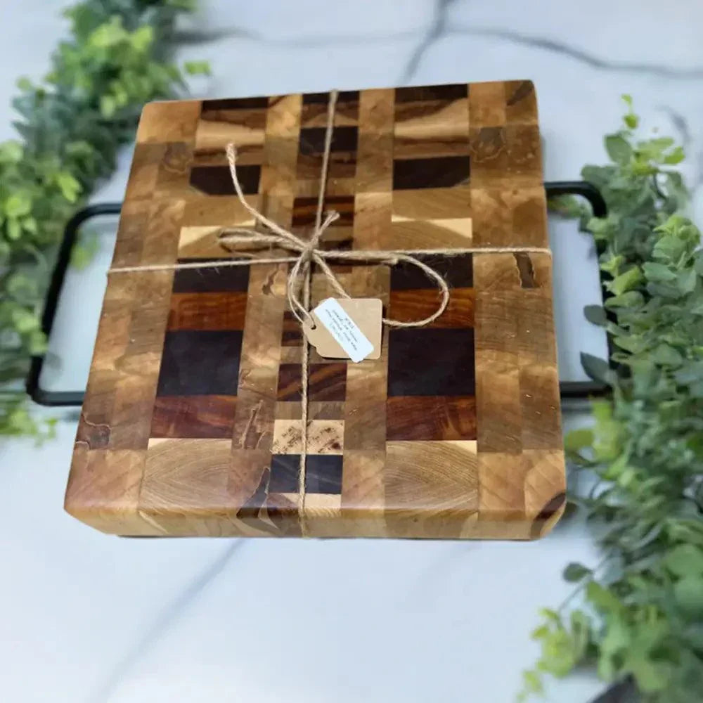Premium 10.5"x11.5"x2.5" butcher block made from Ambrosia Maple, Hickory, Black Walnut, Tigerwood, and Canarywood with non-slip feet on a marble countertop.