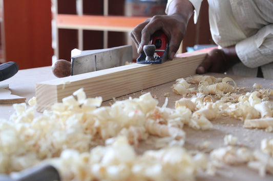 person holding white garlic on brown wooden chopping board