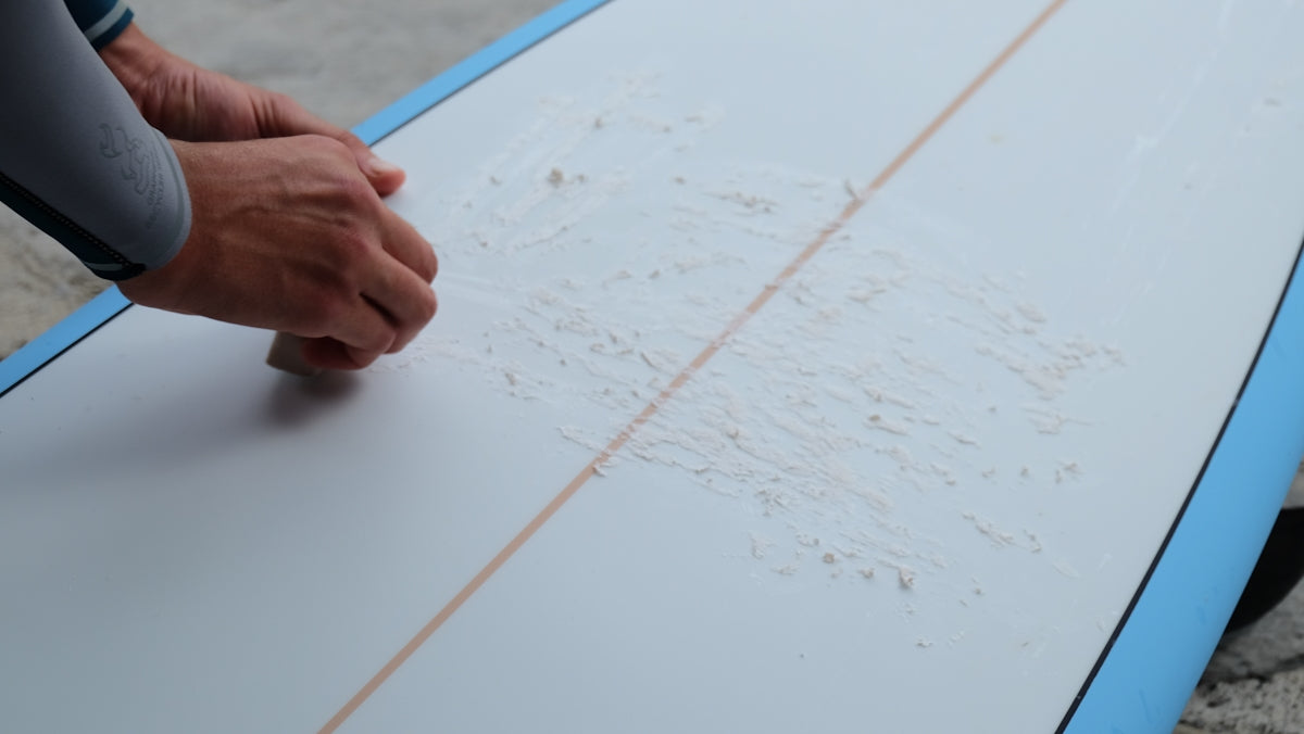 a person is holding a surfboard with writing on it