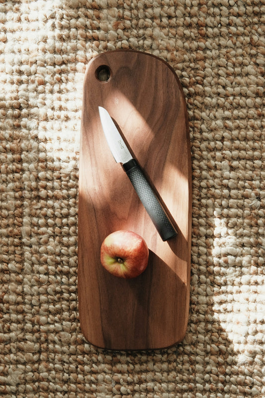 a cutting board with a knife and an apple on it