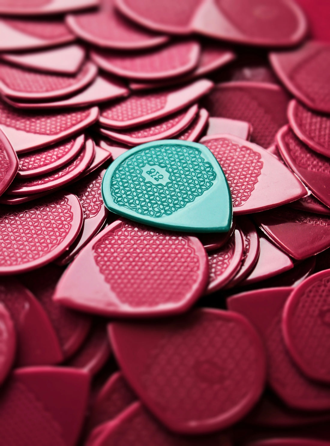 a heart shaped button sitting on top of a pile of pink hearts