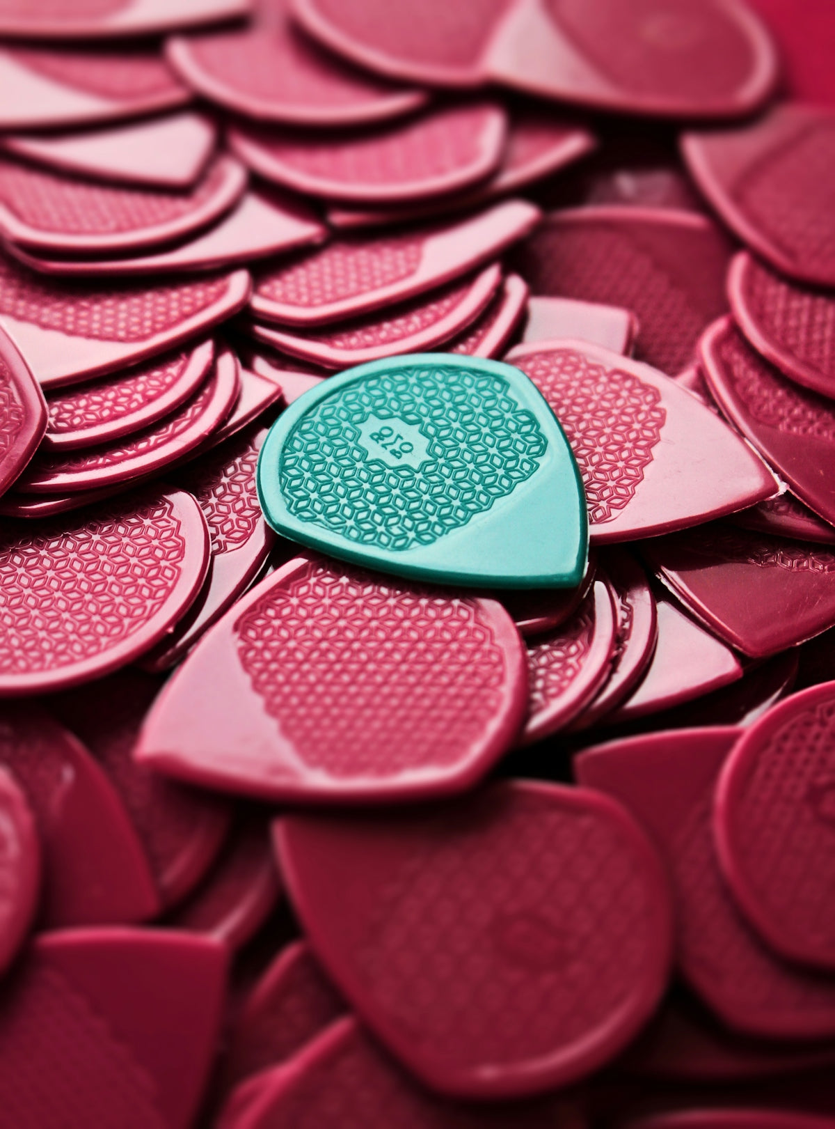 a heart shaped button sitting on top of a pile of pink hearts