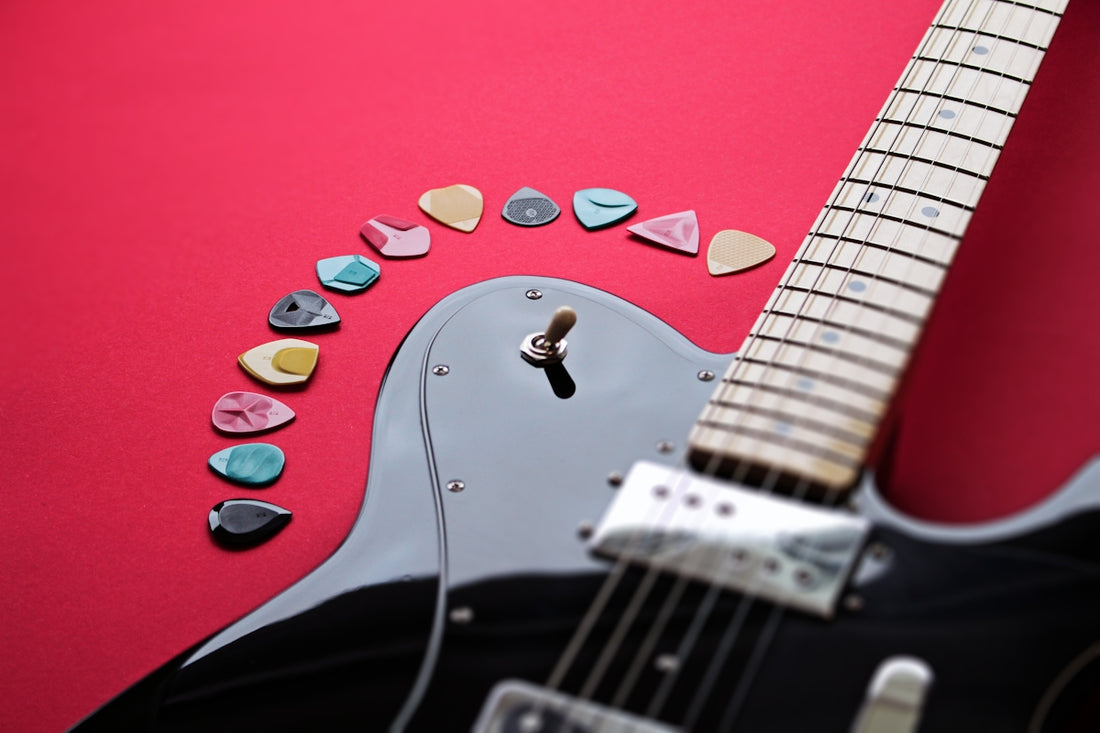 a black guitar with a red background and several guitar picks