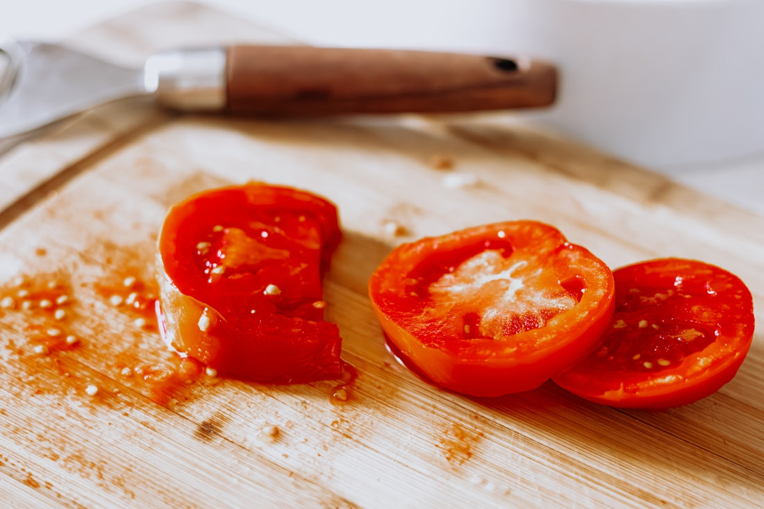 a wooden cutting board topped with sliced tomatoes