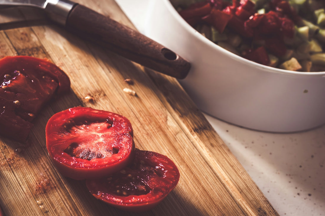 a wooden cutting board topped with sliced tomatoes