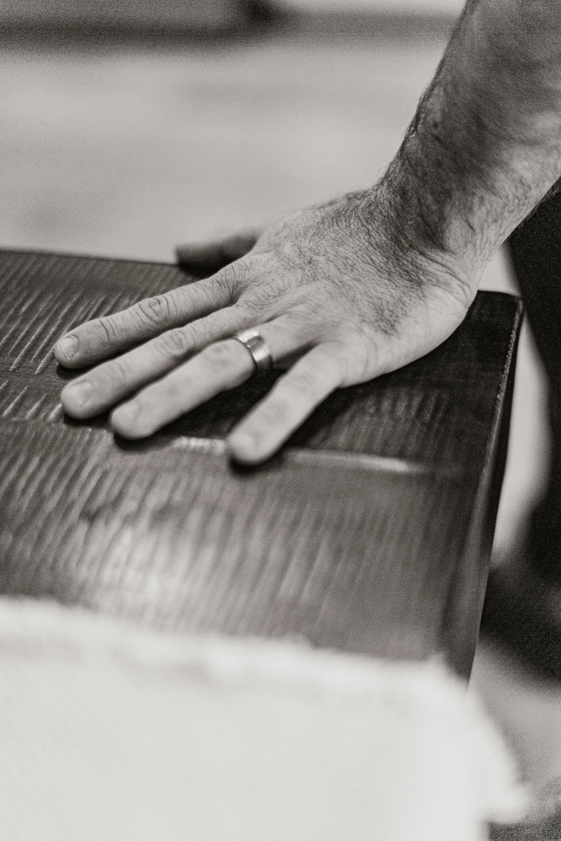 A man's hand resting on a piece of luggage