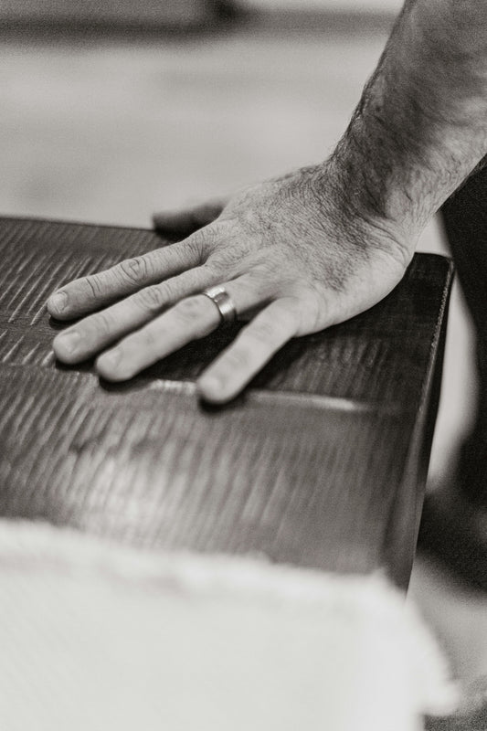 A man's hand resting on a piece of luggage