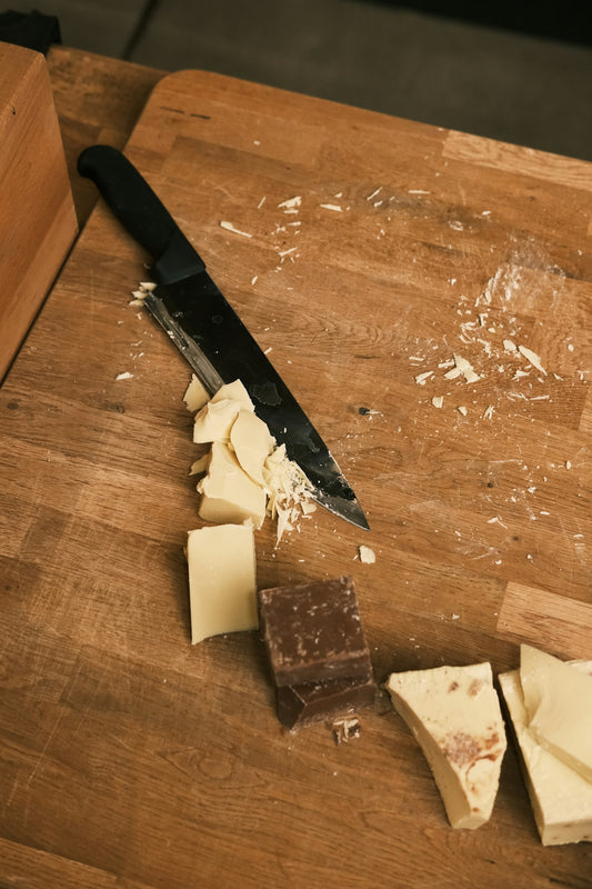 A cutting board with cheese and a knife on it