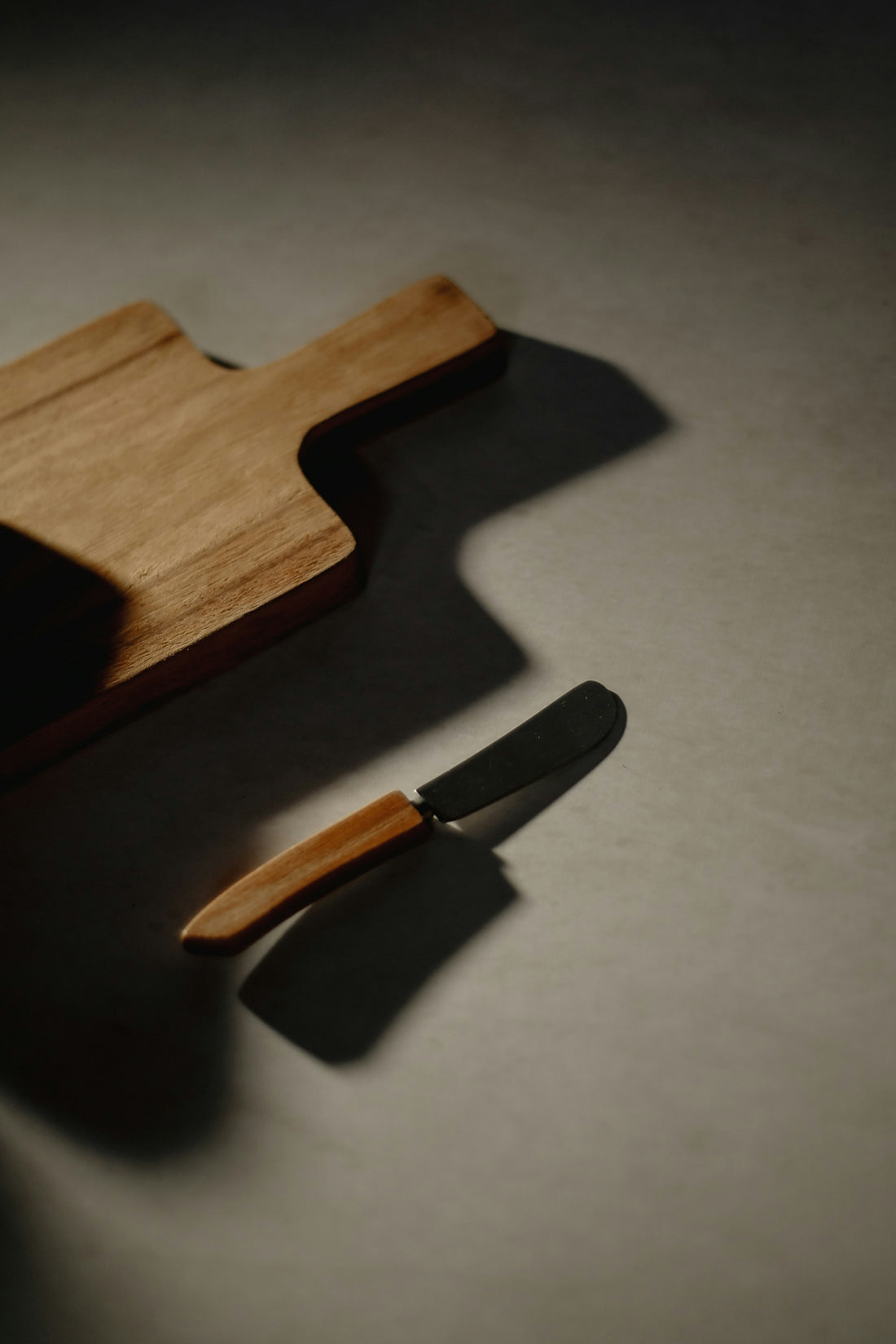 A wooden cutting board with a knife on top of it