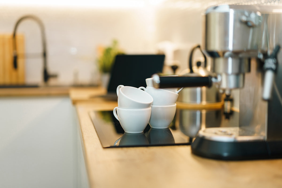 Coffee machine and cups on a modern kitchen counter.