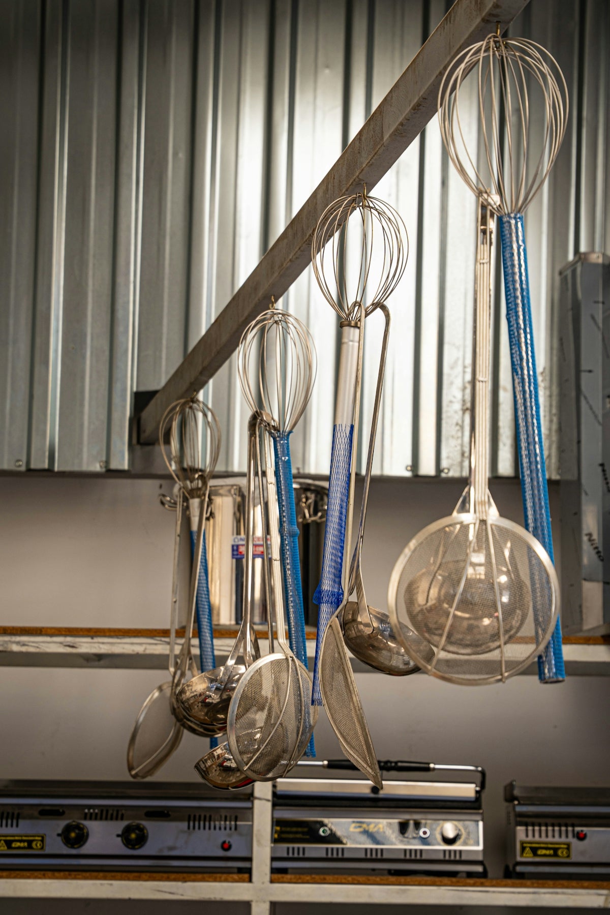 Kitchen utensils hanging on a rack above rack.
