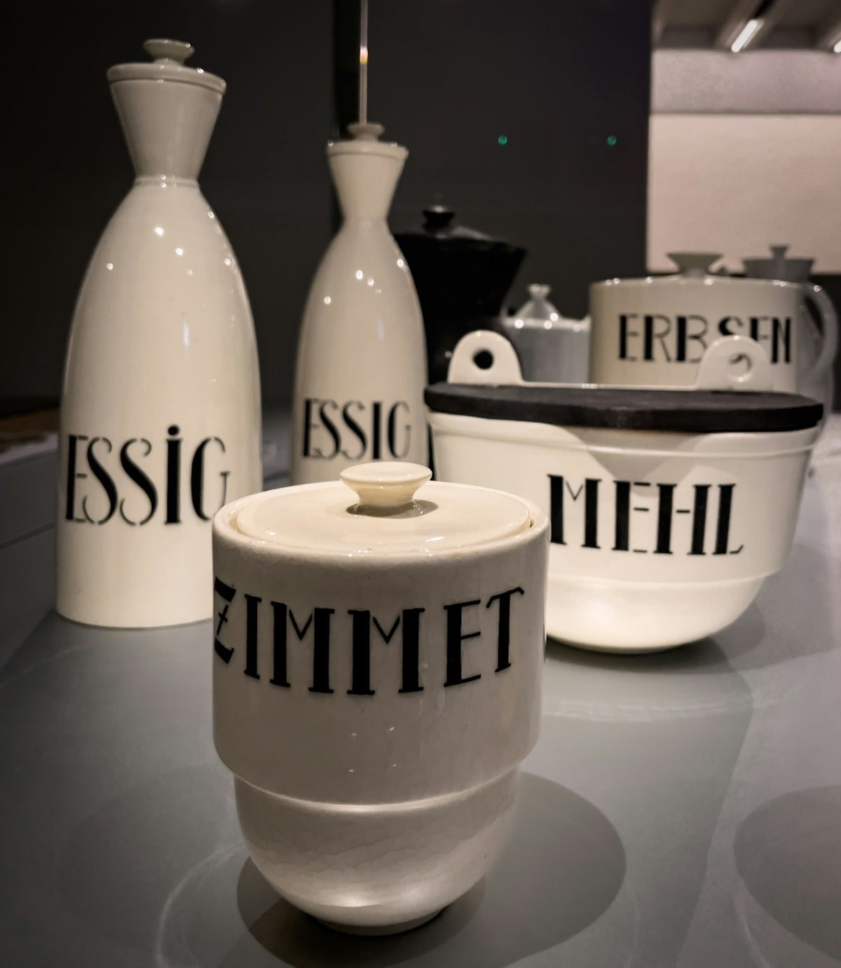 Vintage kitchen canisters labeled 'zimt', 'essig', and 'mehl'.