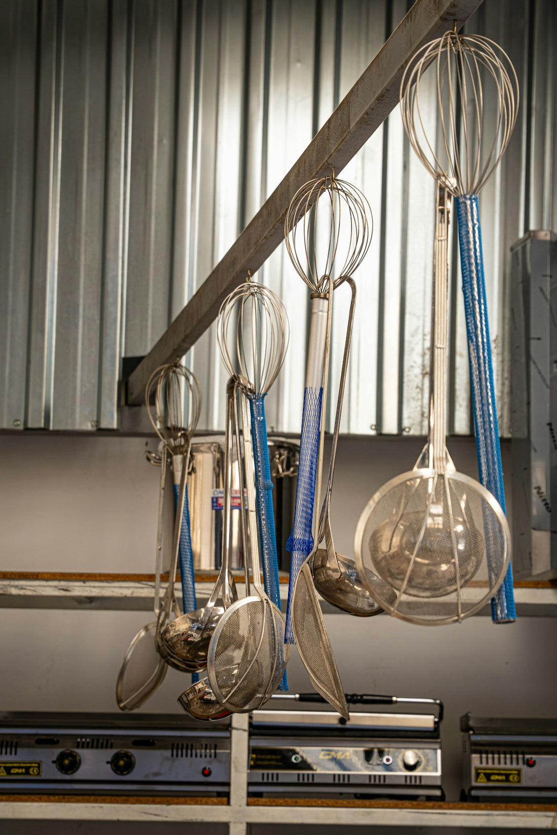 Various kitchen utensils hanging on a rack.