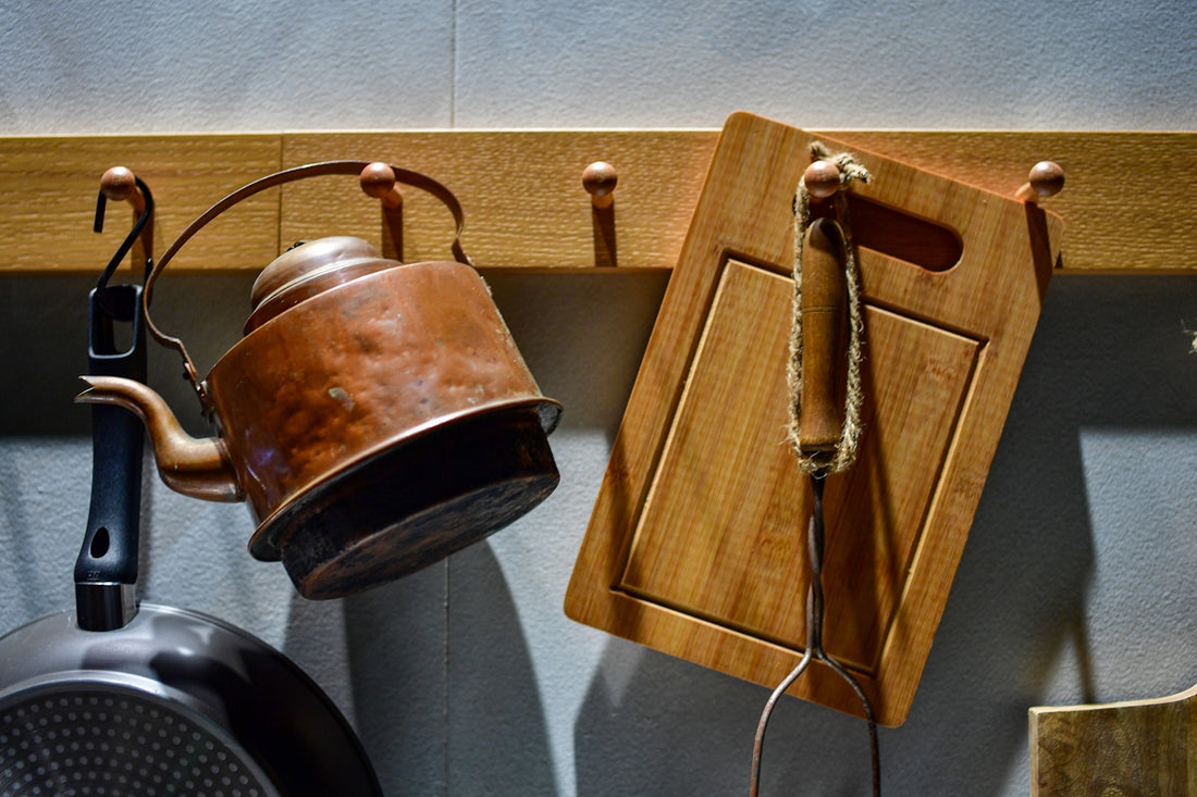 A vintage kettle and cutting board hang on hooks.