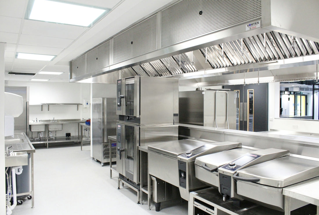 A commercial kitchen with stainless steel appliances and a large ventilation hood