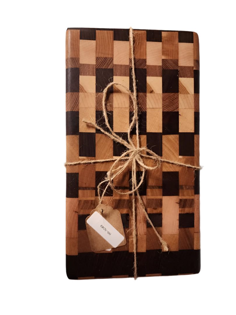 Handcrafted mini end grain chopping board made from black walnut, cherry, and maple wood with intricate pattern, tied with twine.